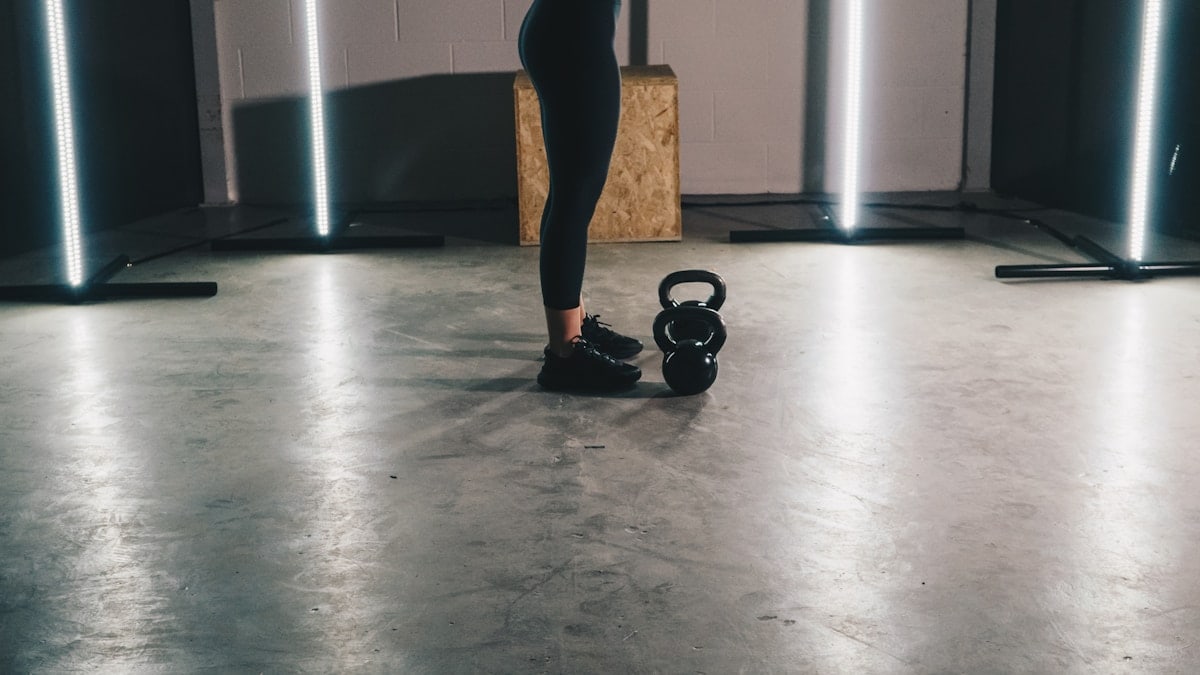 woman in black tank top and black leggings standing on white floor